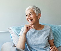 Woman smiling while relaxing on couch at home