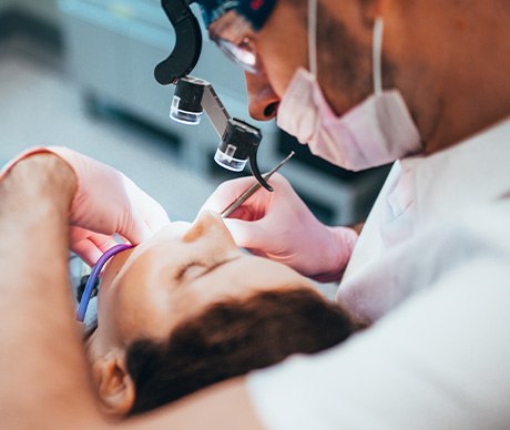 Dentist performing root canal with special glasses