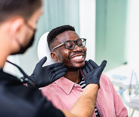 Dentist looking at patient's smile in treatment room