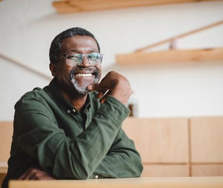 an older man smiling while sitting at home