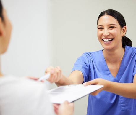 a front desk member smiling at a patient
